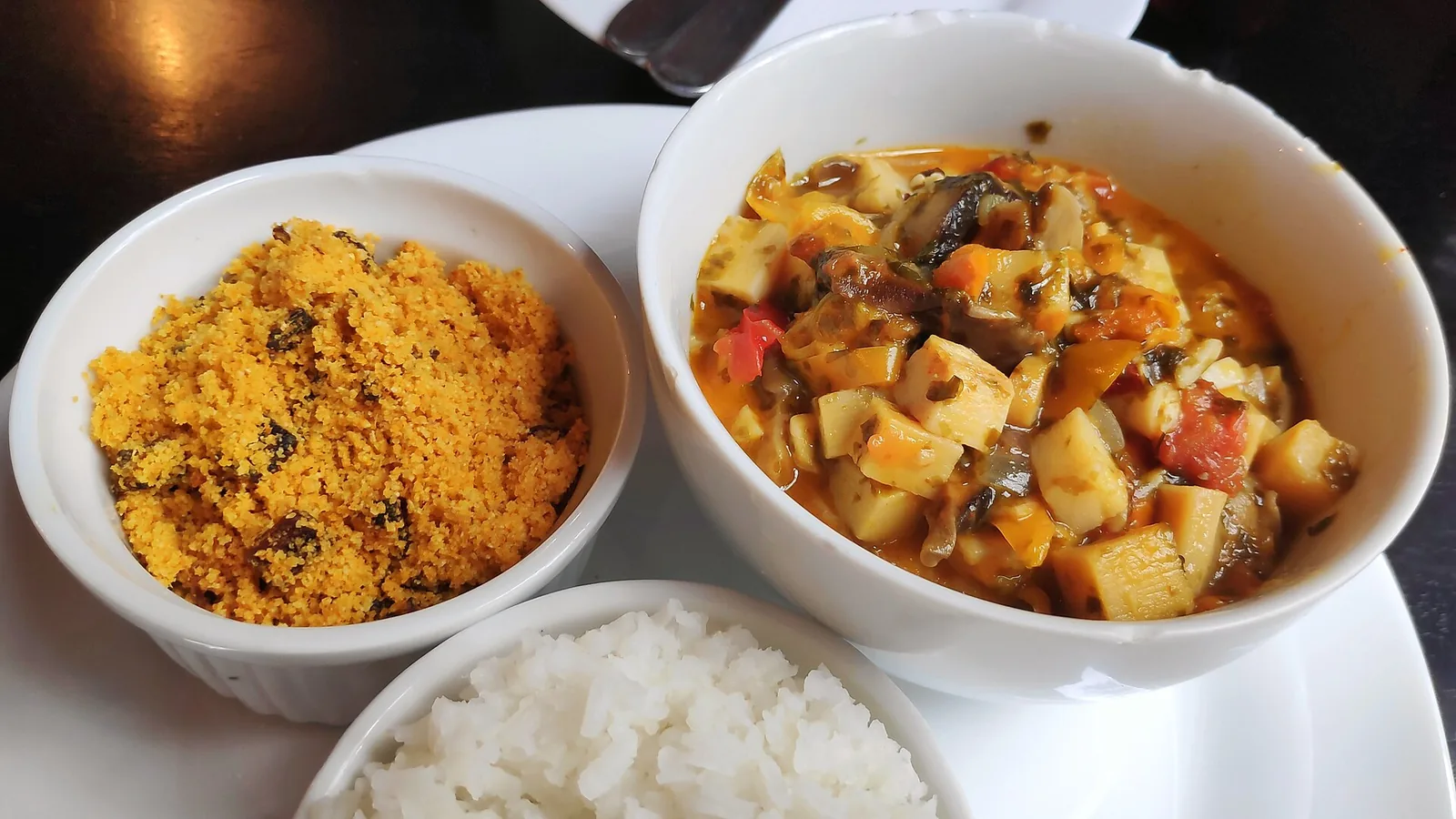 Moqueca served the everyday way, with white rice and farofa — toasted cassava flour, the quiet staple of Brazilian eating.